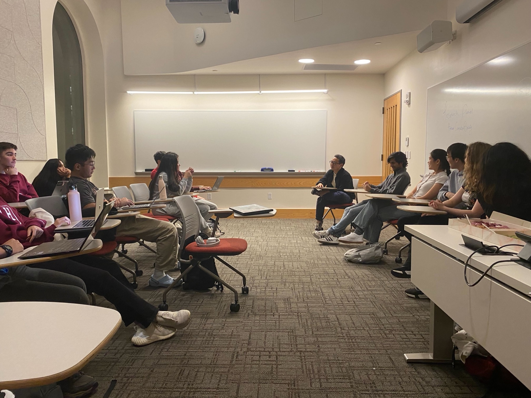Students speaking with panelists at the HCS research panel